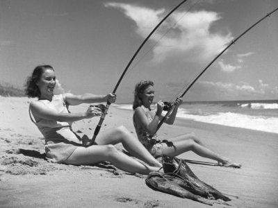 Vintage photo of two women fishing off the beach